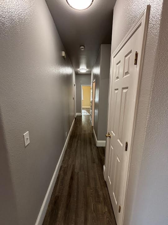 2136 Florence Ave, Sanger, CA 93657 - hallway featuring dark wood-type flooring, attic access, and baseboards