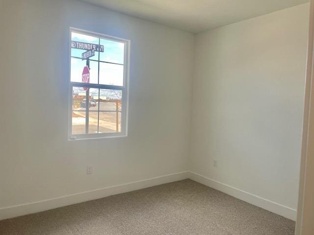 empty room with baseboards and light colored carpet