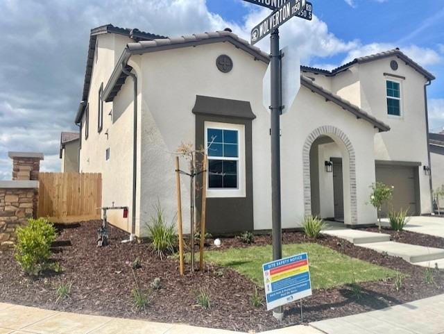mediterranean / spanish-style house with a garage, stucco siding, and fence