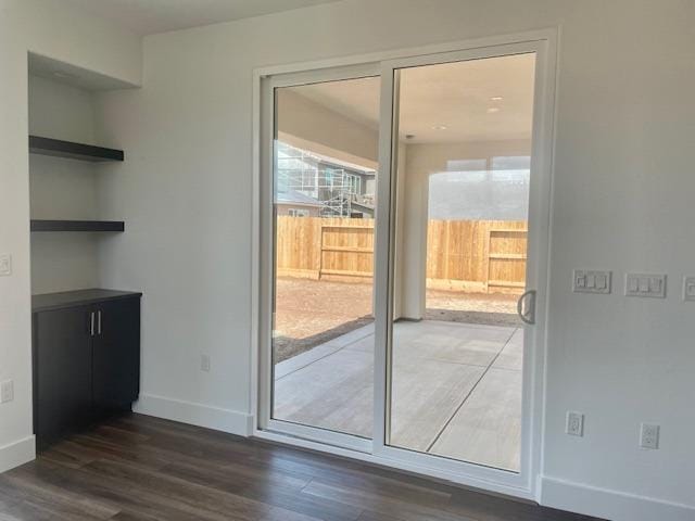 entryway featuring baseboards and dark wood-type flooring