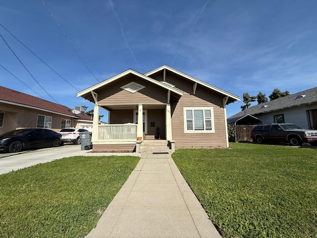 bungalow with a porch and a front lawn