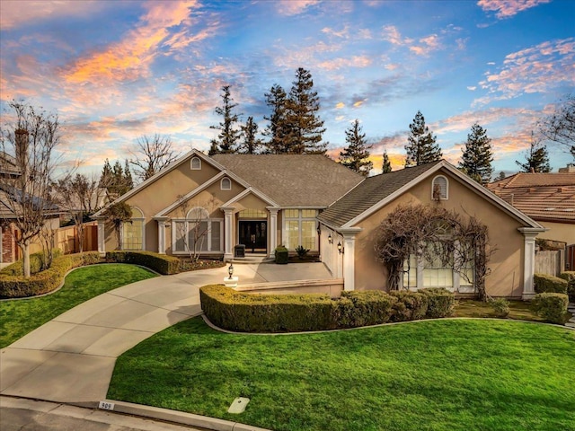 view of front of property featuring a lawn and stucco siding