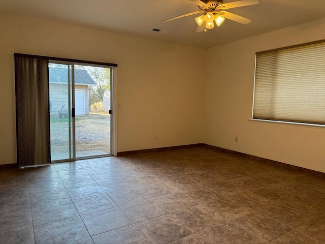 spare room featuring a ceiling fan, visible vents, and baseboards