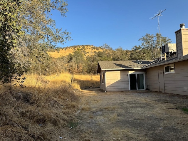 rear view of house with a chimney and a mountain view