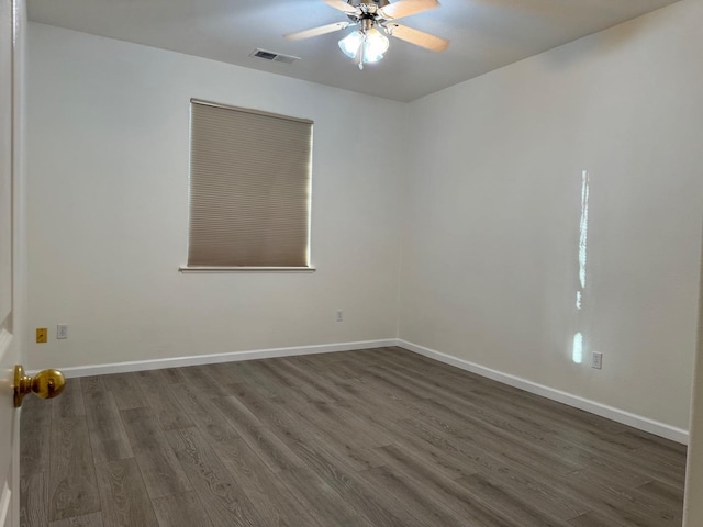 unfurnished room with a ceiling fan, visible vents, baseboards, and dark wood-type flooring