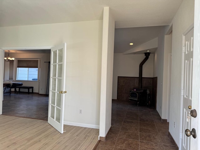 hall with baseboards, a chandelier, and dark wood-style flooring