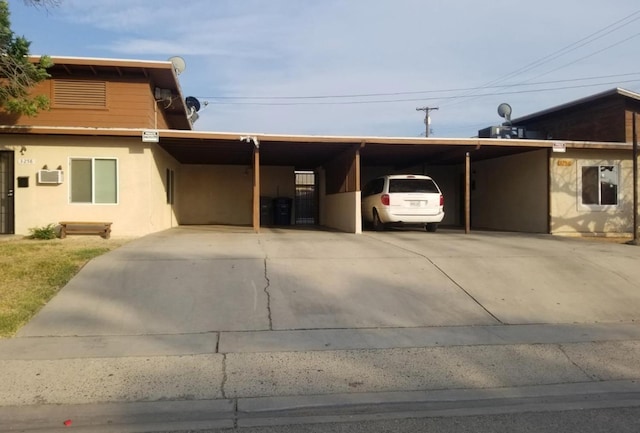 exterior space featuring driveway, an attached carport, and stucco siding