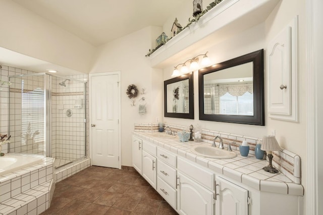 full bath featuring a bath, a stall shower, double vanity, and a sink