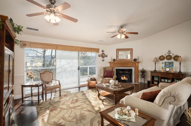 living area with visible vents, ceiling fan, lofted ceiling, and wood finished floors