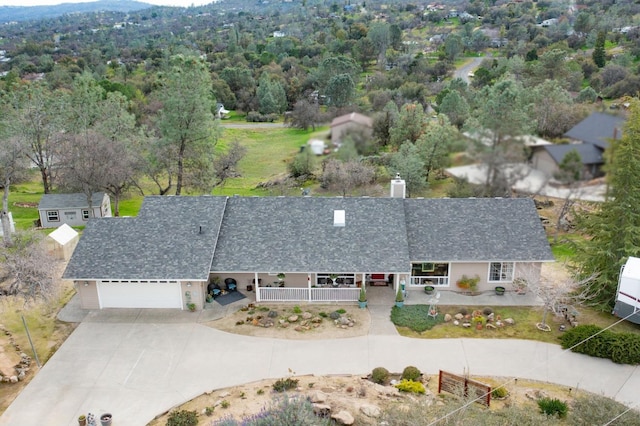 birds eye view of property featuring a forest view