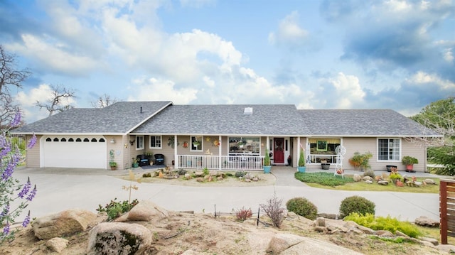 single story home with a porch, concrete driveway, a garage, and roof with shingles