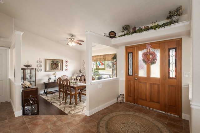 tiled entrance foyer featuring baseboards, lofted ceiling, and ceiling fan