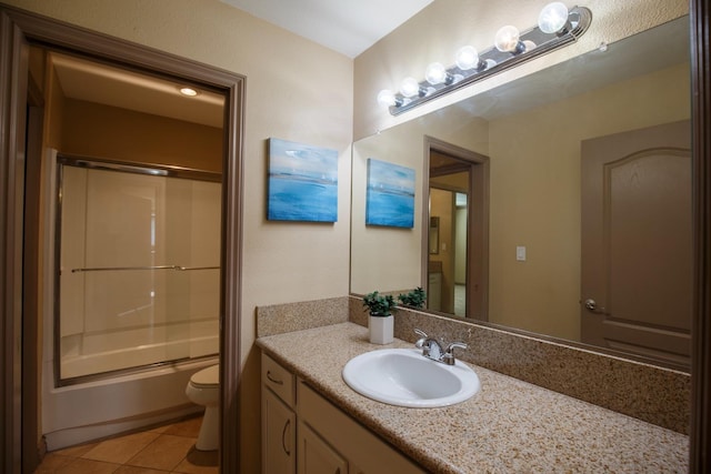 full bath featuring bath / shower combo with glass door, tile patterned flooring, vanity, and toilet