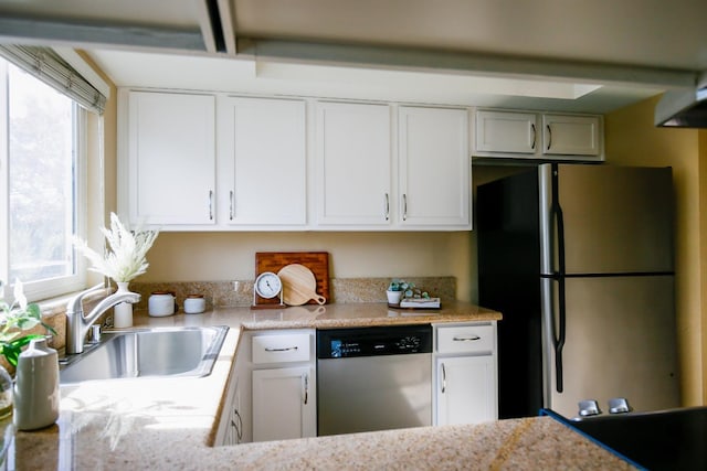 kitchen with appliances with stainless steel finishes, white cabinets, and a sink