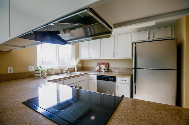 kitchen with a sink, white cabinets, light countertops, stainless steel dishwasher, and freestanding refrigerator