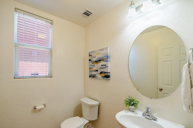 bathroom with visible vents, a sink, and toilet