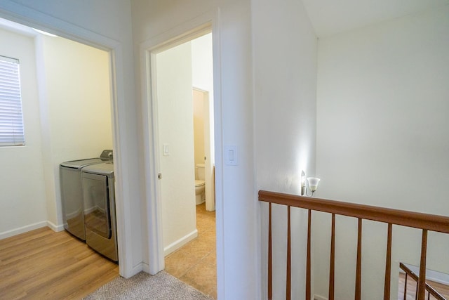 corridor with washing machine and dryer and baseboards