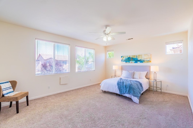 bedroom with baseboards, ceiling fan, visible vents, and light colored carpet