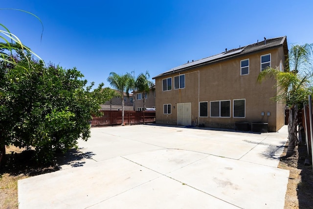 rear view of property featuring fence, a patio, and stucco siding