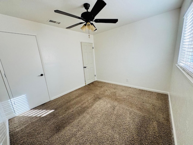 unfurnished bedroom with carpet, visible vents, ceiling fan, and baseboards