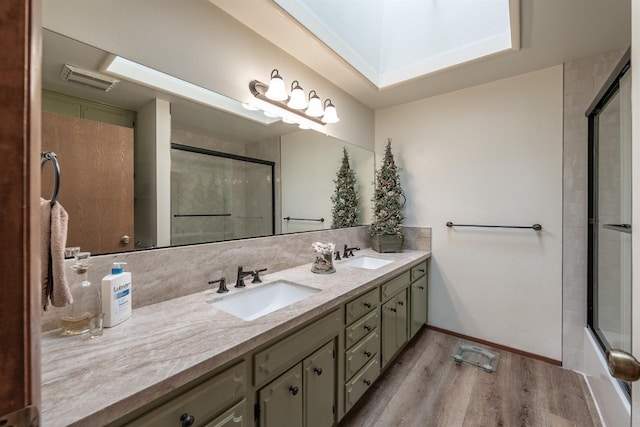 full bathroom featuring double vanity, backsplash, a sink, and wood finished floors