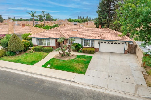 mediterranean / spanish home featuring driveway, a garage, a tile roof, fence, and a front lawn