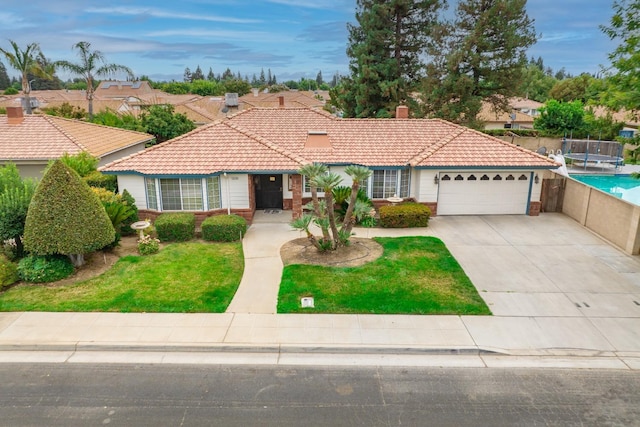 view of front facade with driveway, a tile roof, a front lawn, and an attached garage