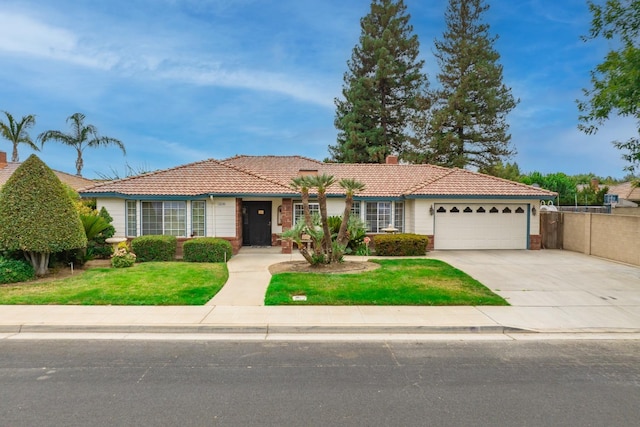 ranch-style house with a tile roof, a chimney, a garage, driveway, and a front lawn