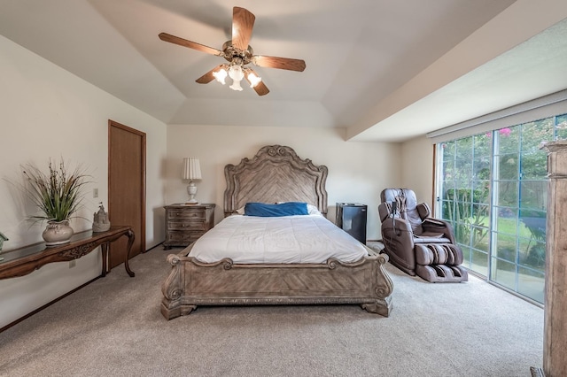 carpeted bedroom featuring access to exterior, ceiling fan, and a raised ceiling