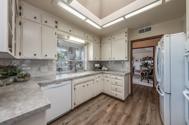 kitchen featuring white appliances, a sink, visible vents, white cabinets, and light countertops