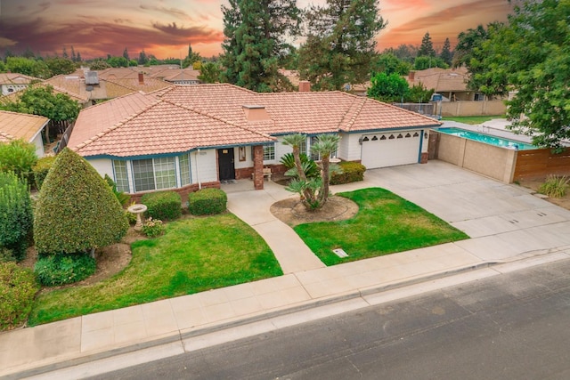 mediterranean / spanish-style home with a garage, a front yard, a tile roof, and fence