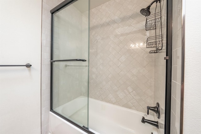 bathroom with bath / shower combo with glass door