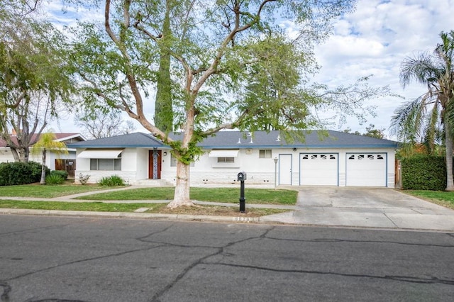 ranch-style house with a garage, a front yard, driveway, and stucco siding