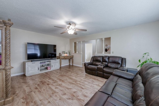 living room featuring a ceiling fan, light wood-type flooring, a textured ceiling, and baseboards