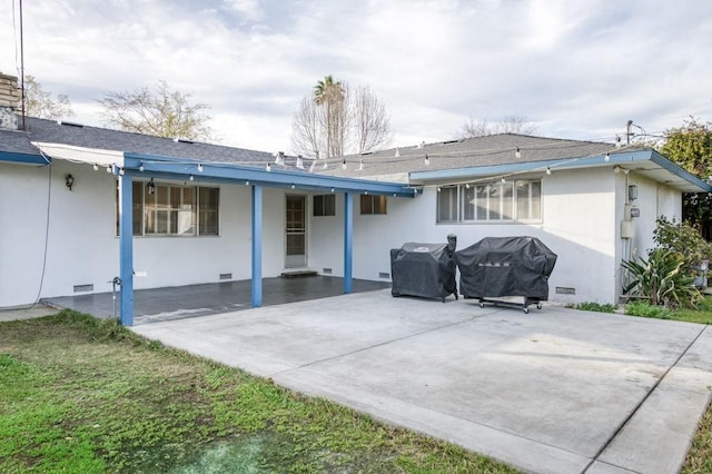 rear view of house with a shingled roof, crawl space, a patio area, and stucco siding