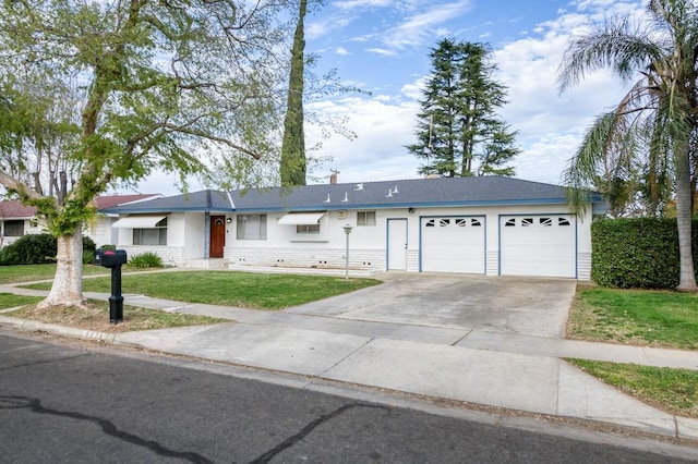 ranch-style house featuring a garage, concrete driveway, and a front yard