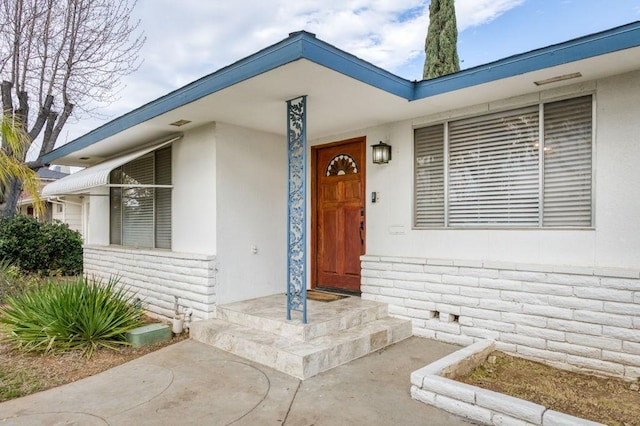 view of exterior entry with stucco siding