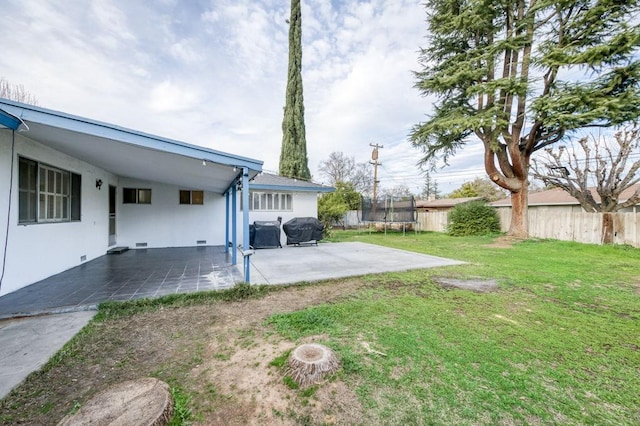 view of yard with a fenced backyard, a trampoline, and a patio