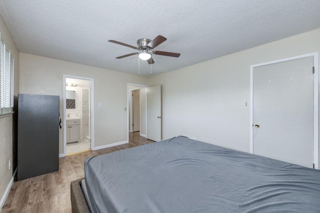 bedroom with connected bathroom, a textured ceiling, ceiling fan, and wood finished floors