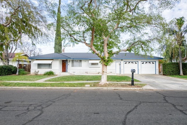 single story home with a garage, concrete driveway, and a front lawn