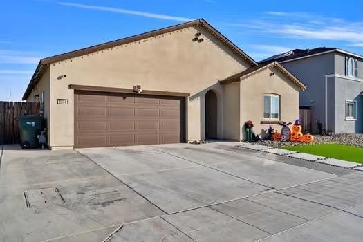 mediterranean / spanish-style house featuring a garage, concrete driveway, and stucco siding