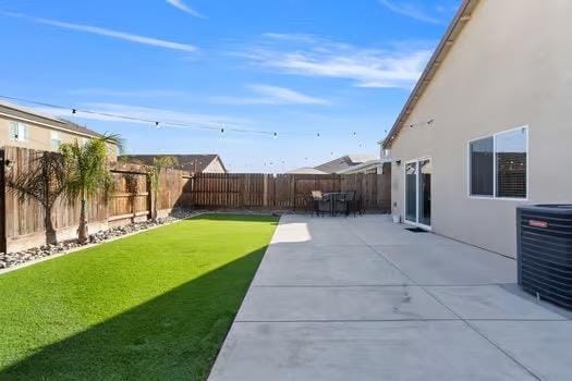 view of yard with central air condition unit, a patio area, and a fenced backyard