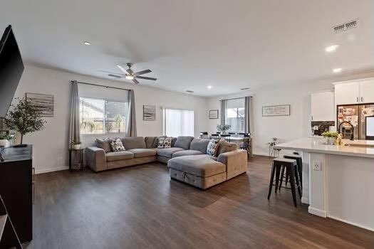 living room with visible vents, ceiling fan, dark wood finished floors, and a wealth of natural light