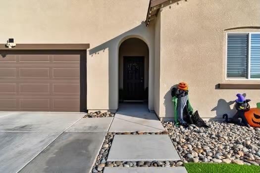 doorway to property featuring concrete driveway and stucco siding