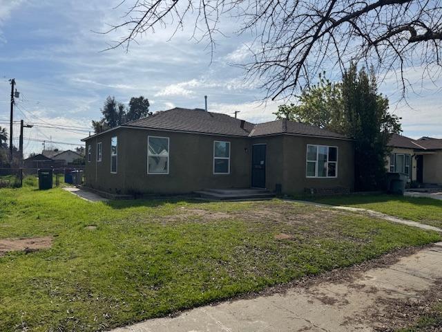 view of front of property featuring a front yard, fence, and stucco siding