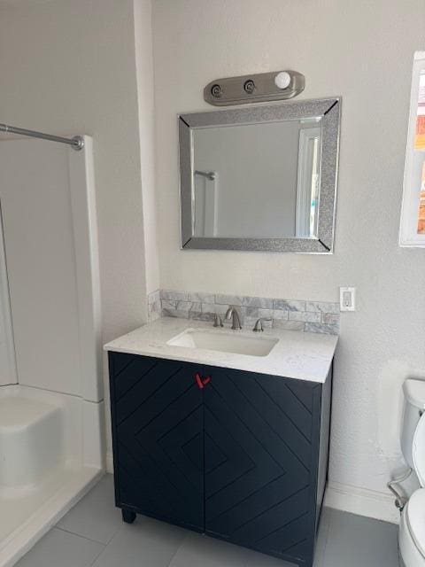 bathroom with toilet, a shower, and vanity