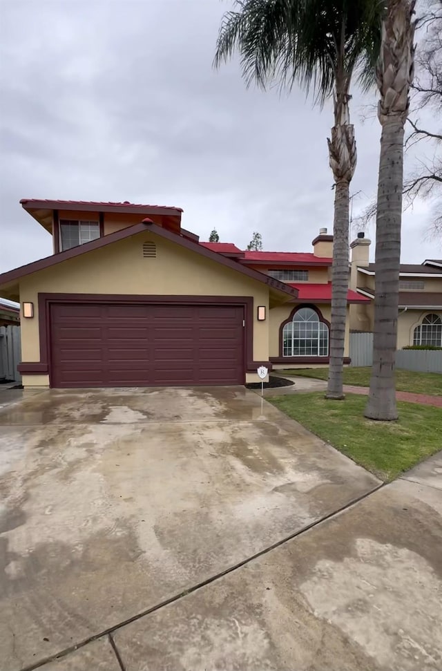 view of front of home with an attached garage, concrete driveway, and stucco siding