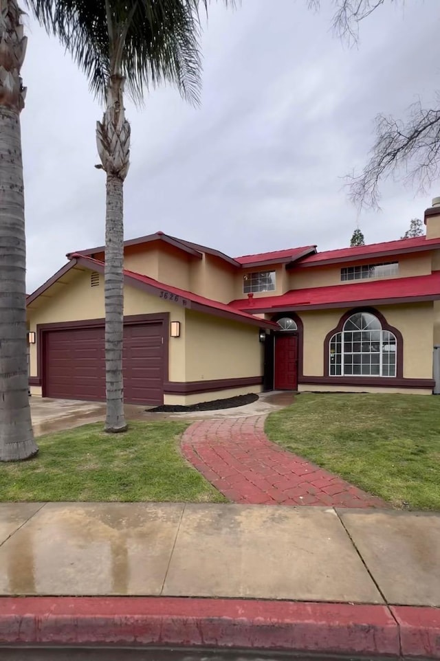 view of front of home with a garage, a front yard, and stucco siding