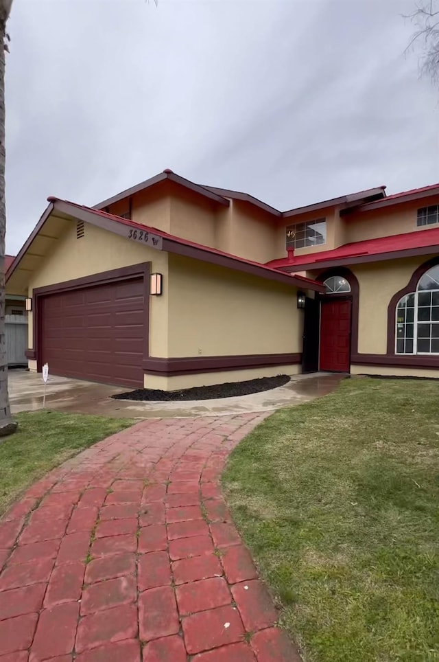 view of front of house featuring a garage, a front yard, and stucco siding