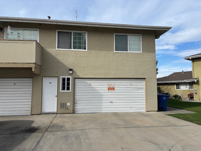 view of front facade featuring driveway, an attached garage, and stucco siding